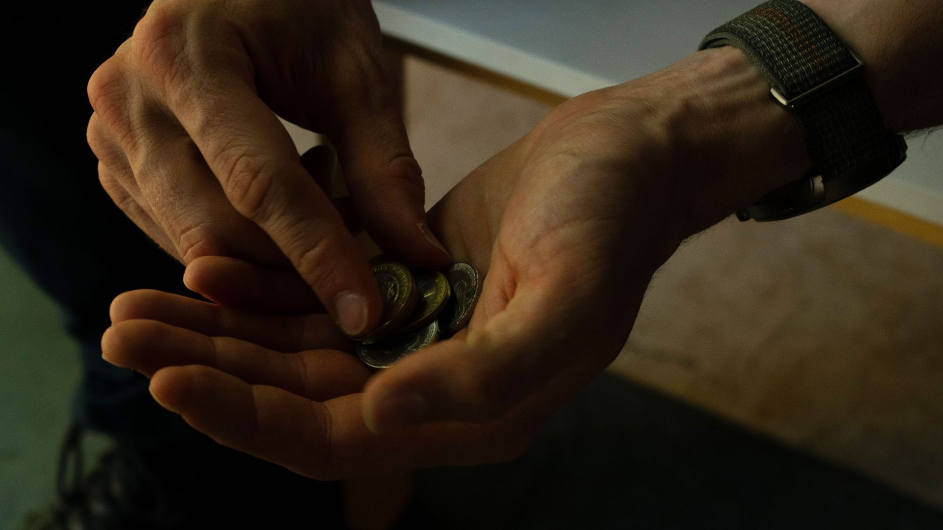 Close-up of hands counting coins, implying budgeting or financial planning.