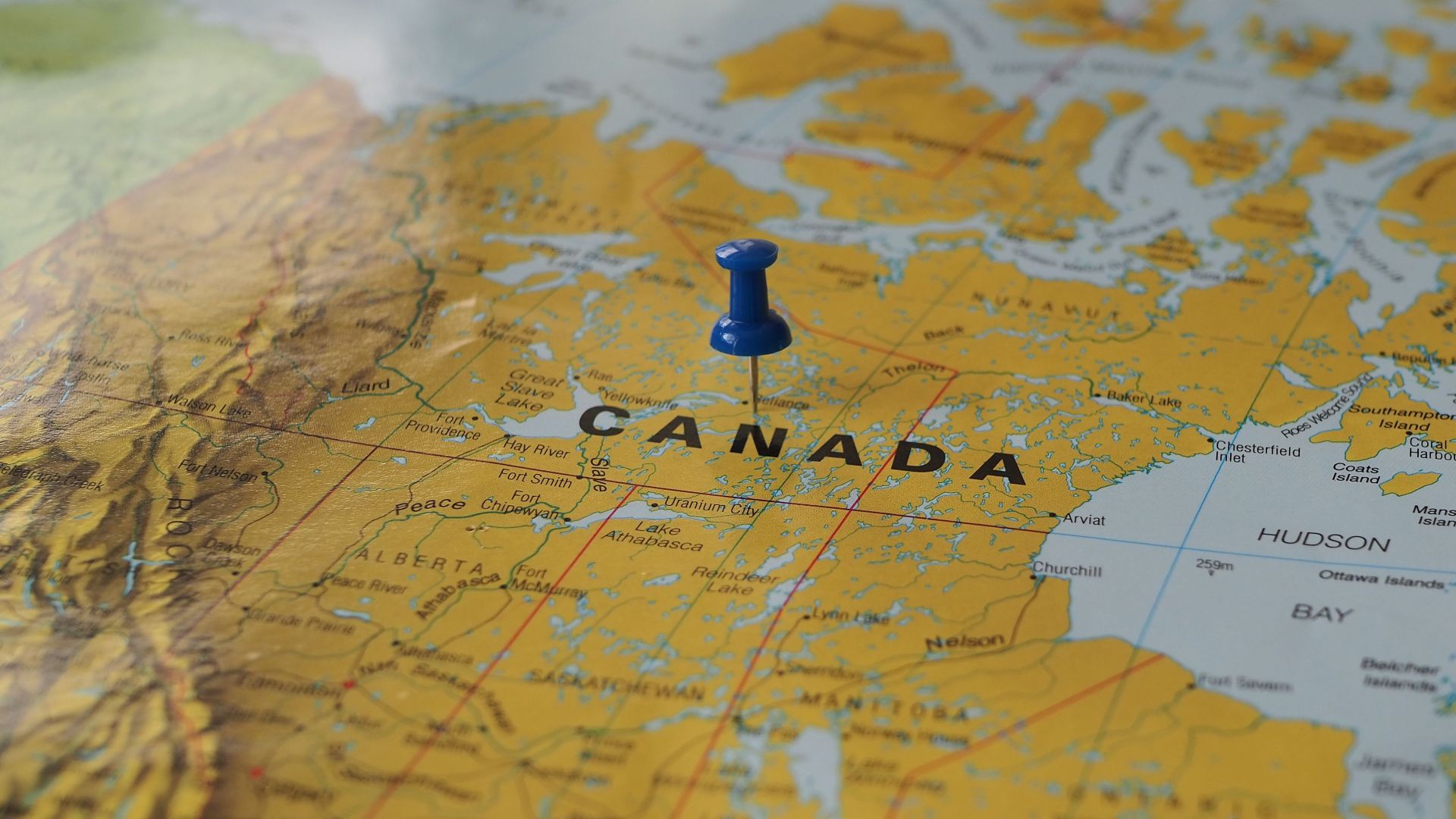 Yellow map of Canada with a blue pin marking a location.