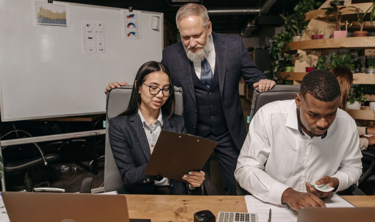A diverse group of professionals working in a modern office with laptops