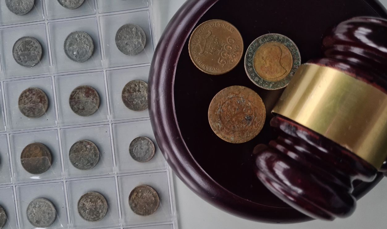 Auctioneers or judges gavel and old coins. Numismatic collection or auction concept and judgment