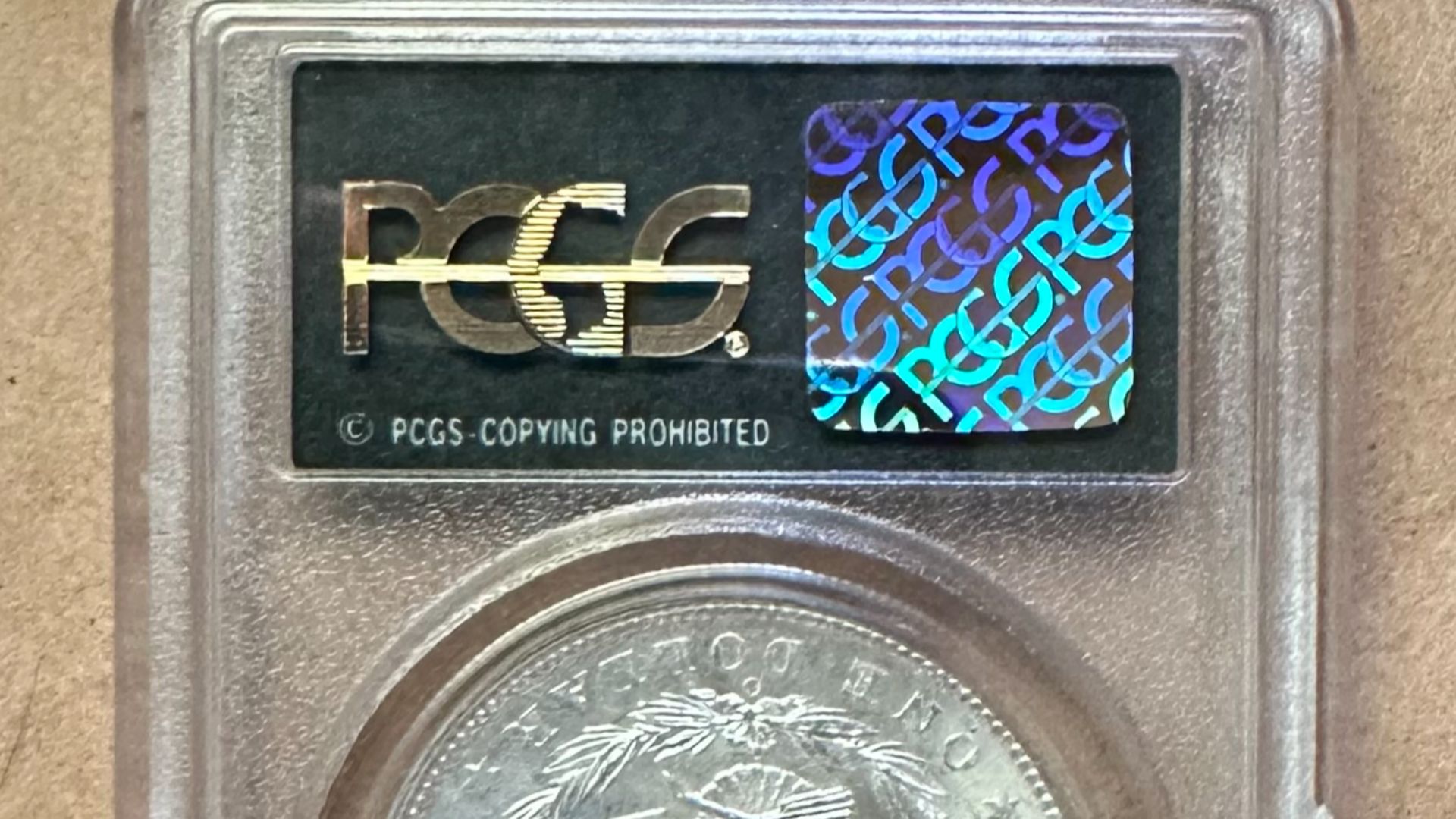 19th century Morgan dollar in PCGS coin slab. Image depicts the hologram on the reverse