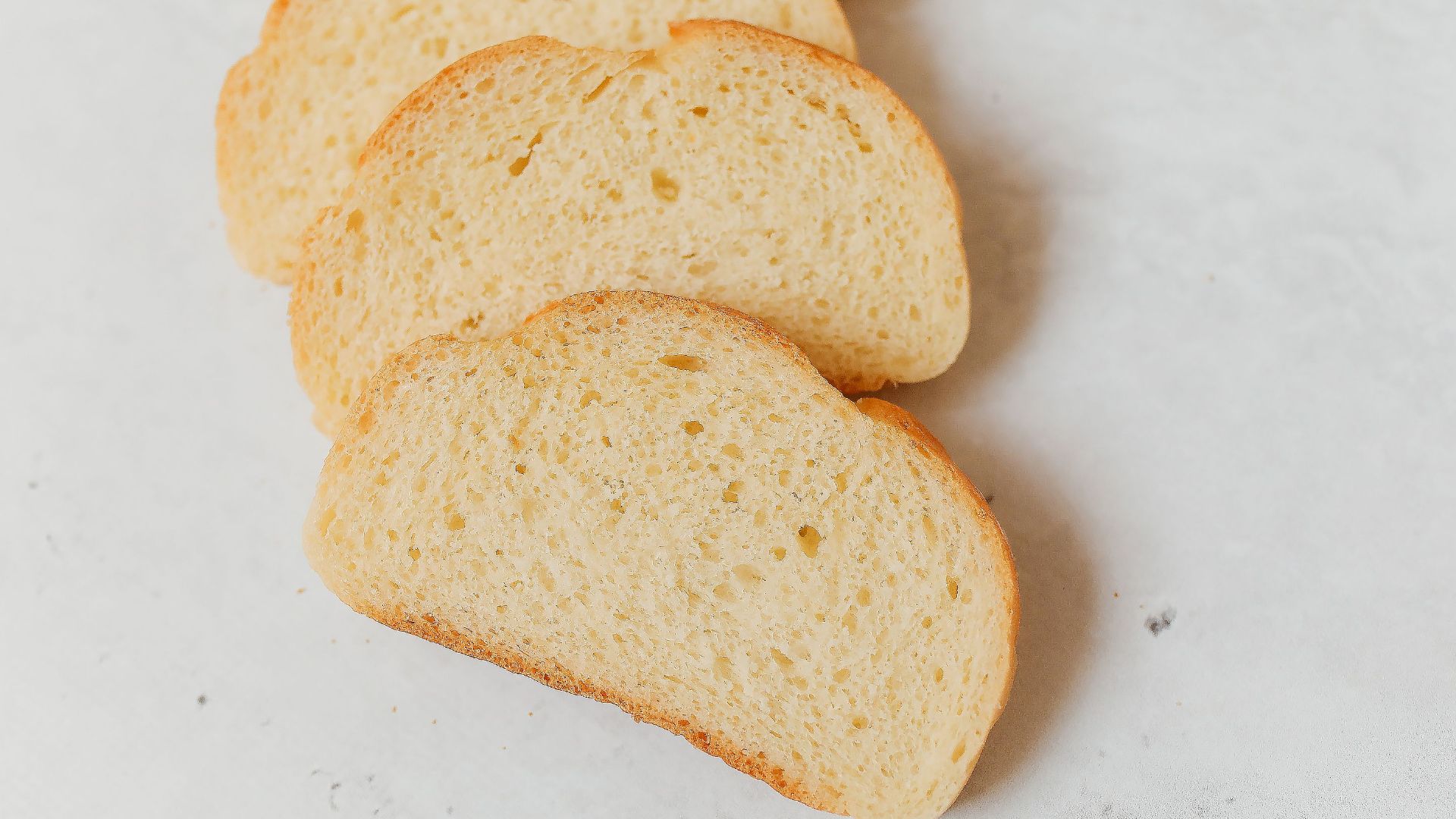 Close-up of freshly sliced white bread showcasing its soft texture on a bright surface.