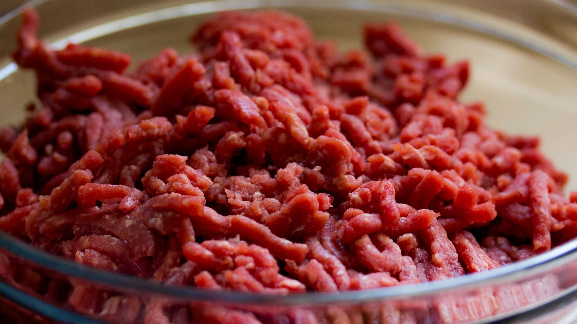 High-quality image of fresh ground beef in a glass bowl, ideal for culinary and food-related themes.