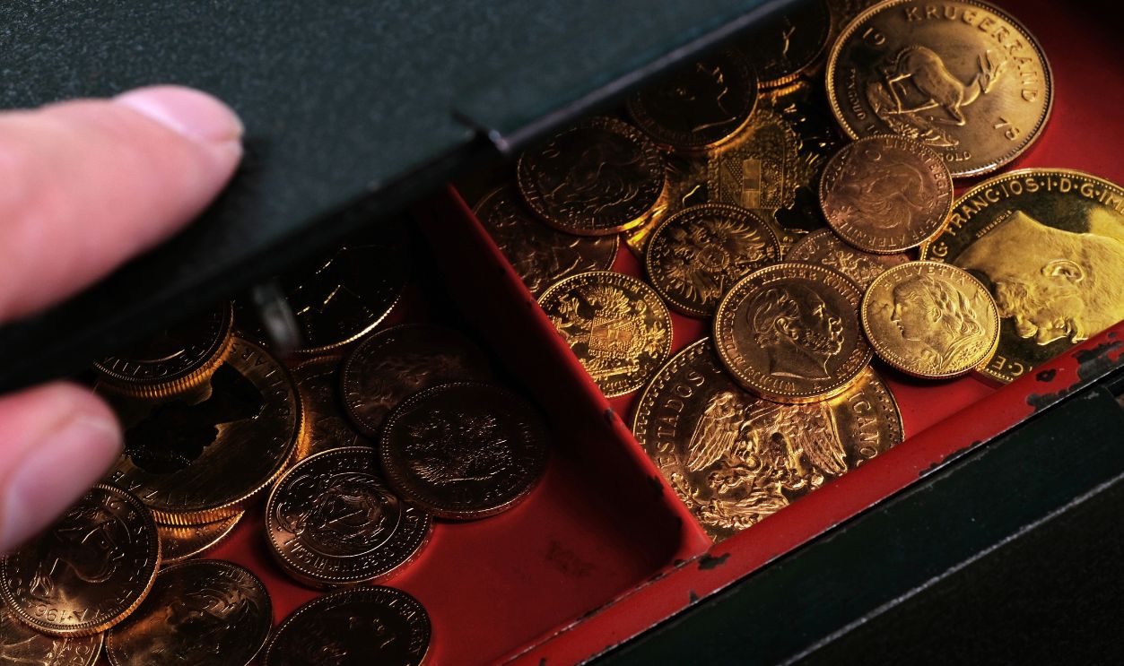 Shutterstock-2170384039, A pile of gold coins in an open cash box