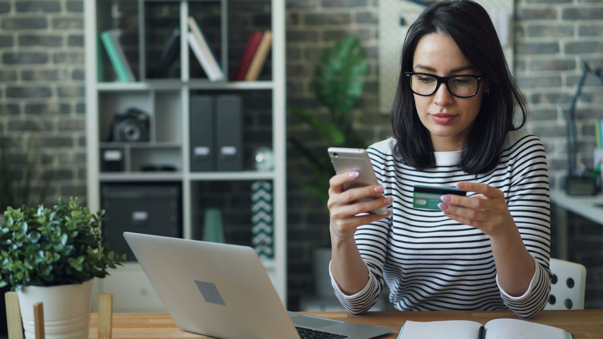 a woman sitting at a table looking at her cell phone