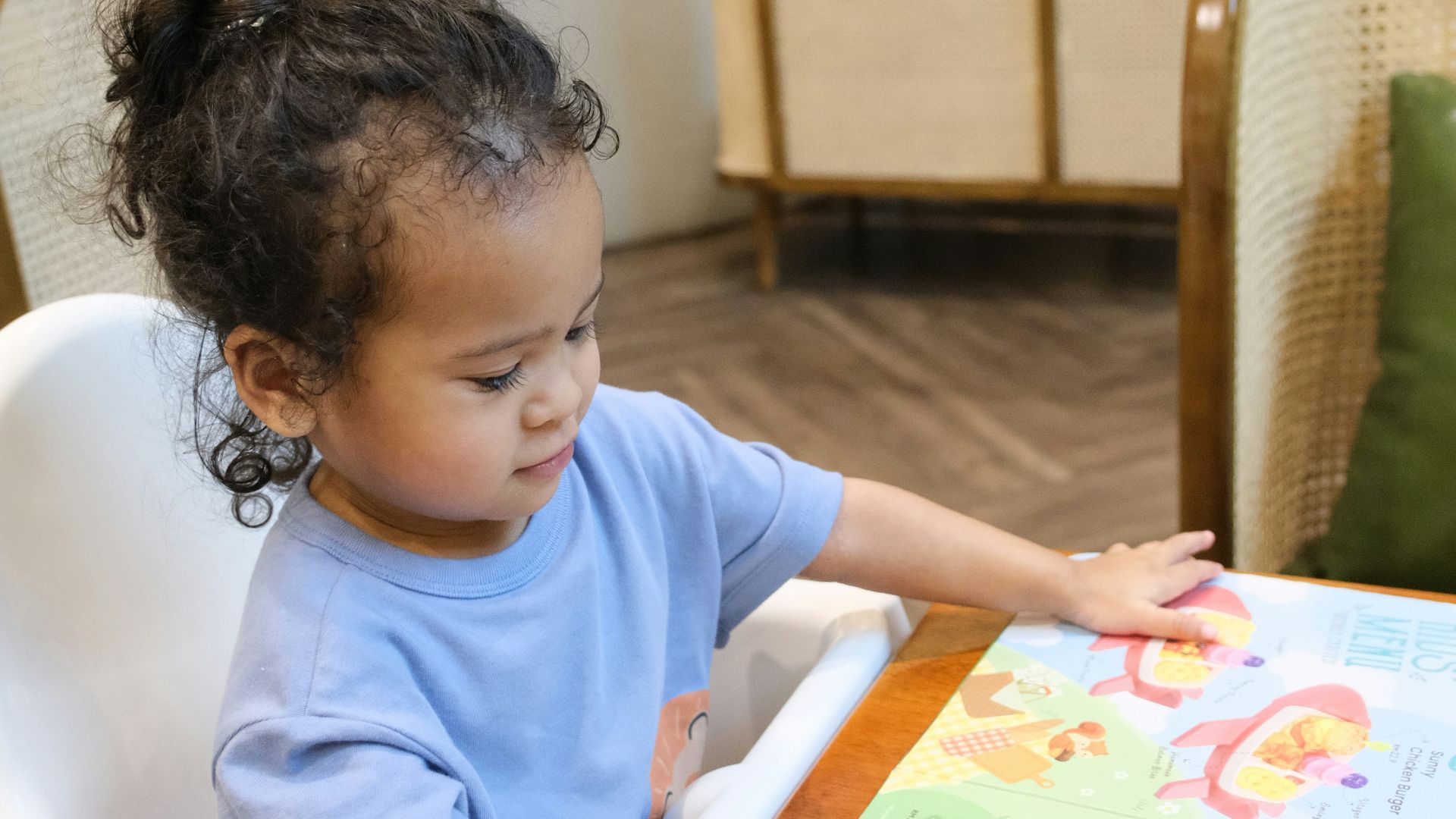 Young child pointing at a colorful menu
