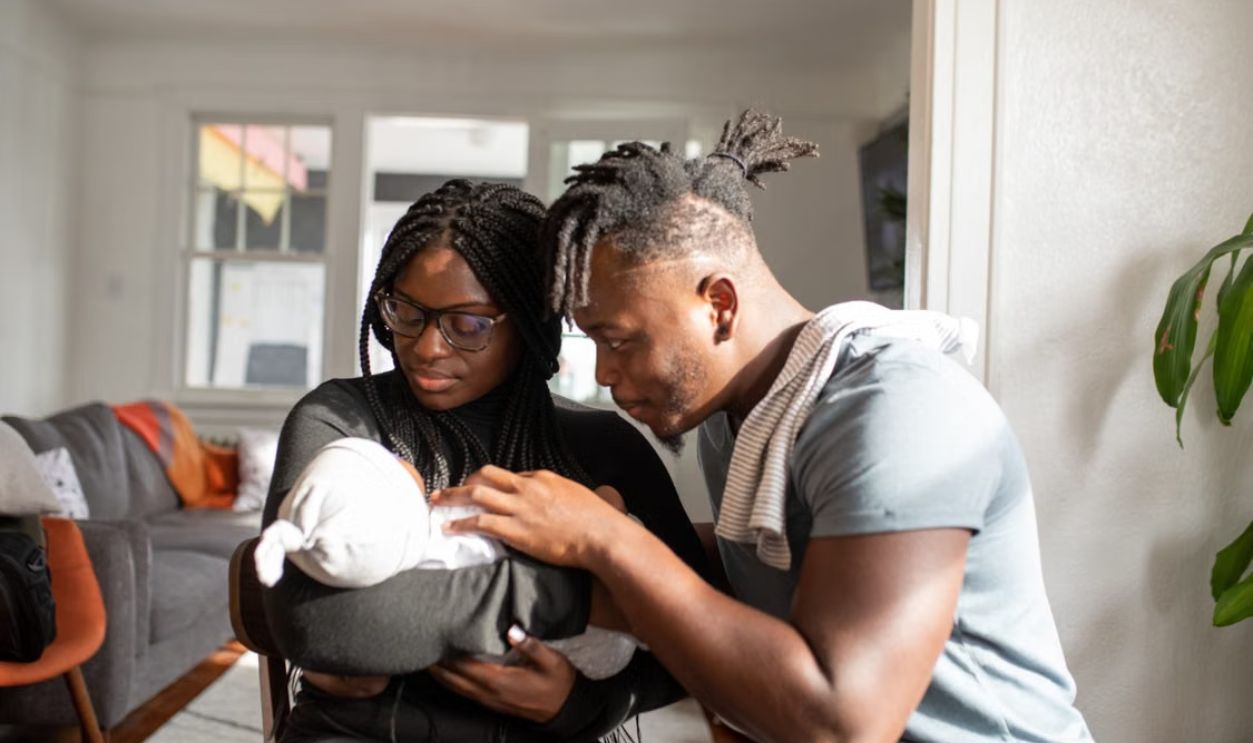 Loving parents embracing their newborn baby at home, capturing a tender family bond.