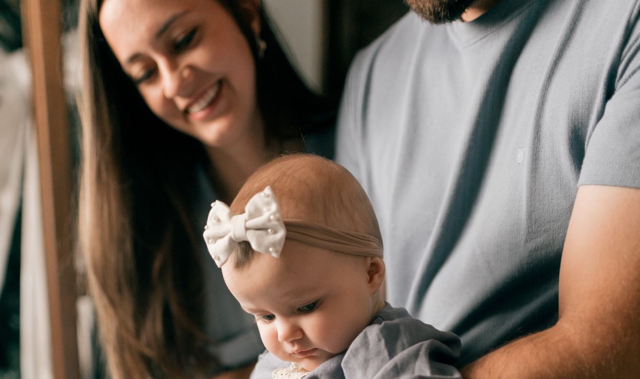 Joyful family interaction with baby and siblings indoors, capturing love and bonding.
