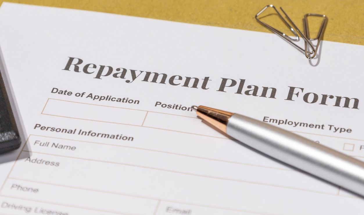 Repayment Agreement Document with Pen – Tabletop View of Loan and Finance Planning