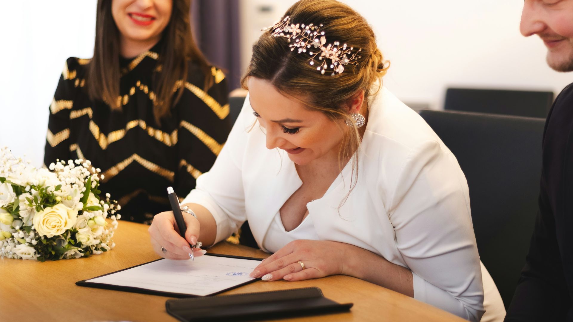 Bride signs the marriage certificate with a smile