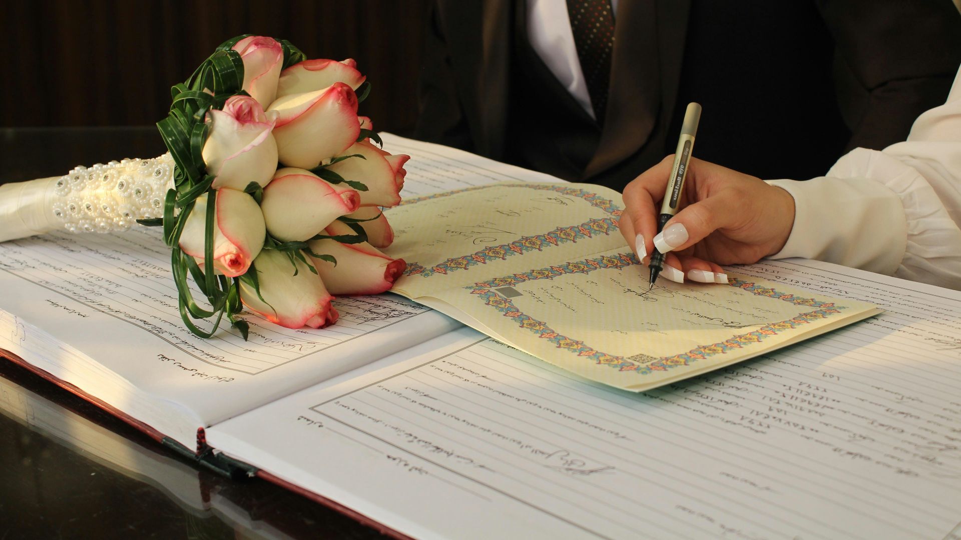 A man in a suit writing on a piece of paper