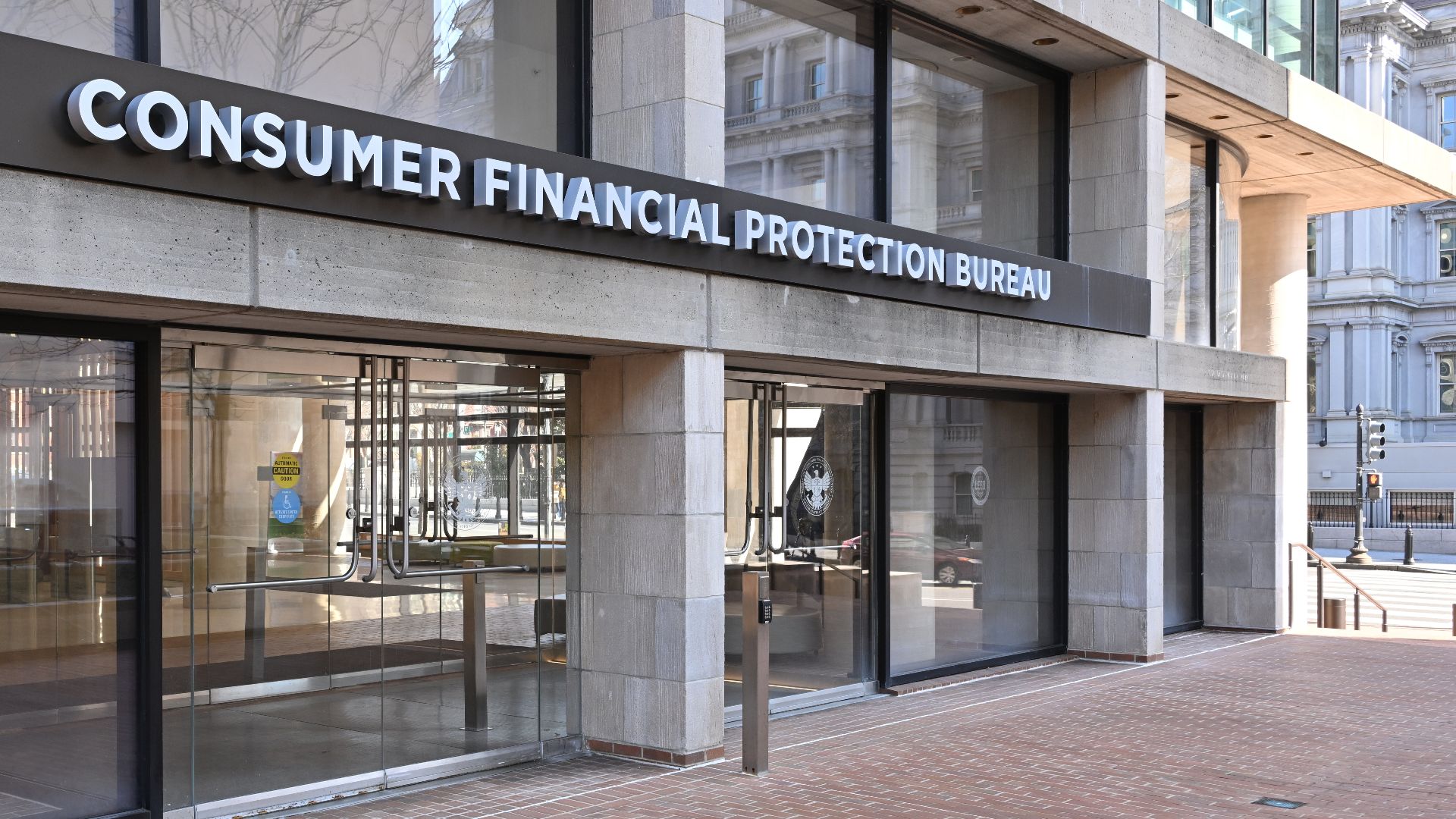 The entrance to the Consumer Financial Protection Bureau headquarters with the bureau's name above it. 1700 G Street NW, Washington, DC 20552.
