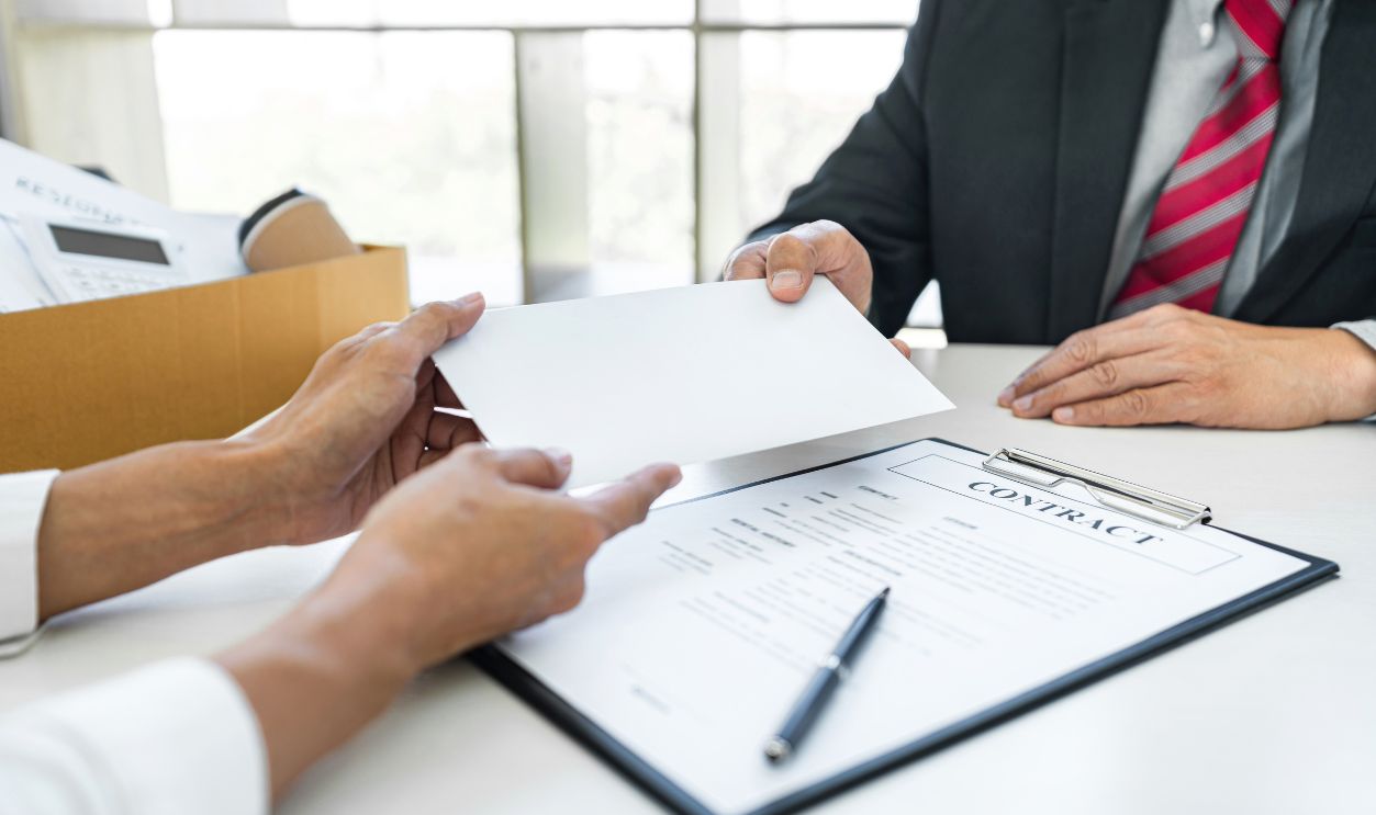 Hand of employer filing final remuneration after employee to write a document letter of resignation, resign concept.