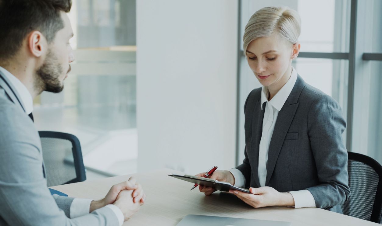 Two professionals in a modern office discussing business.