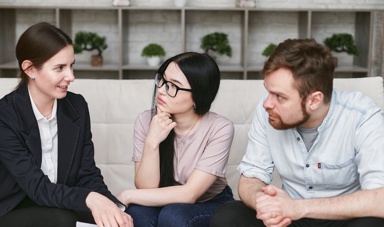 Three adults discussing business inside, focused on cooperation and strategy.