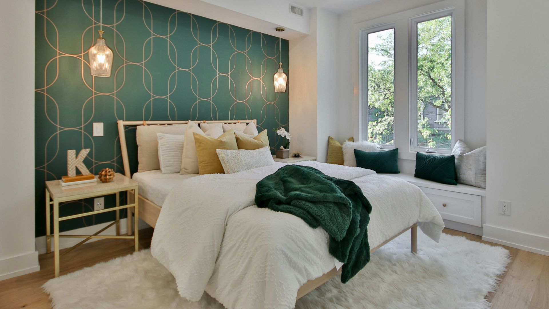 a bedroom with a green wall and a white bed