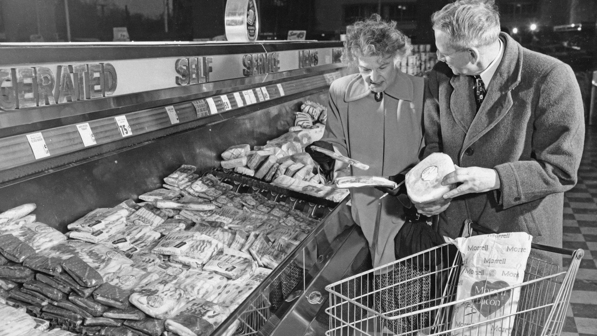 Couple shops for meat in a grocery store