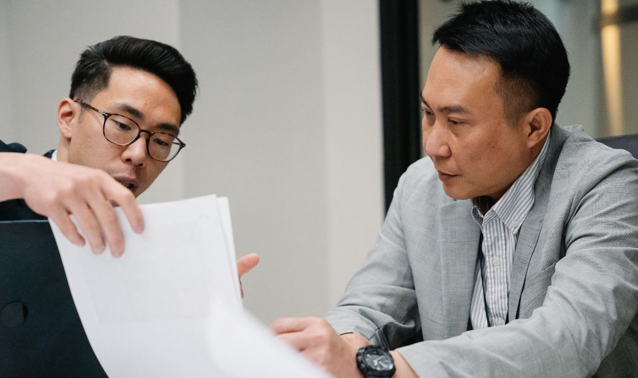 Two professional men engaged in a focused discussion in a contemporary office environment