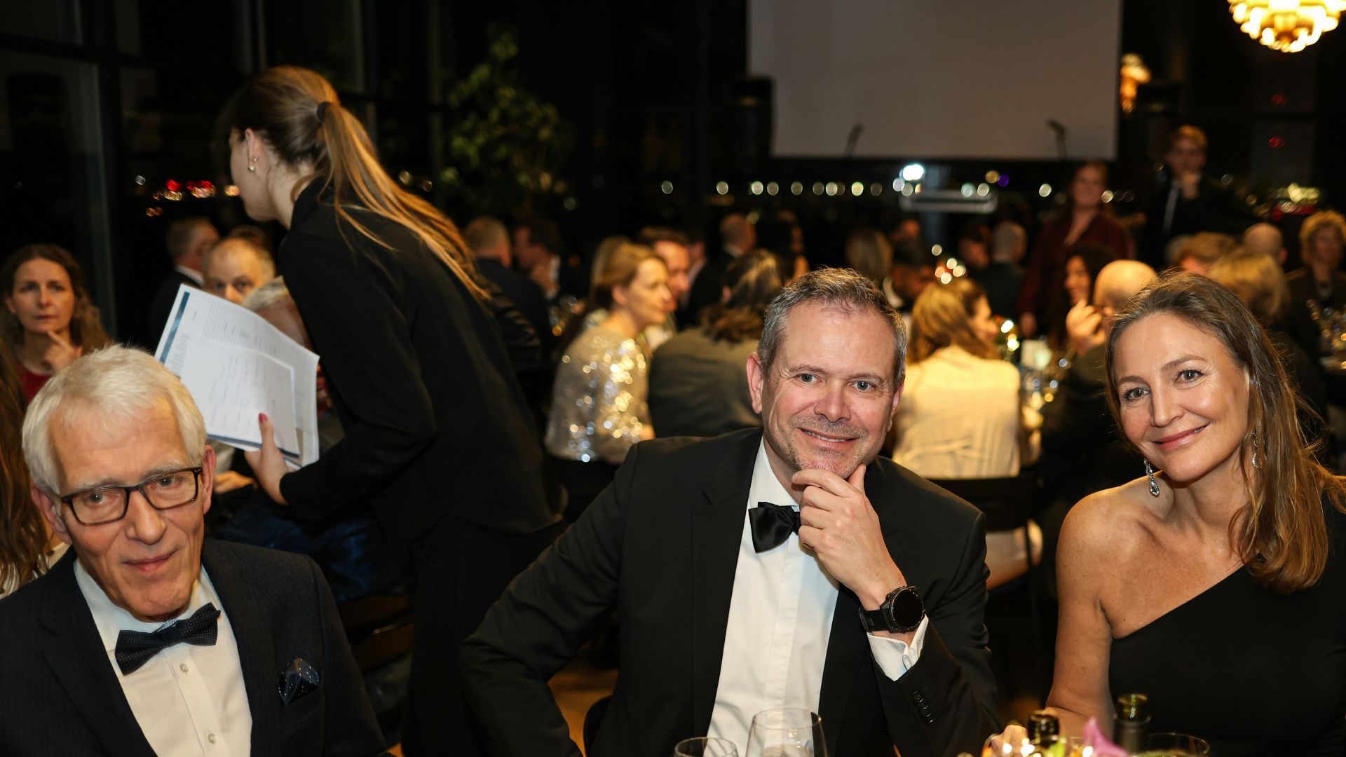 Three people at a formal dinner event
