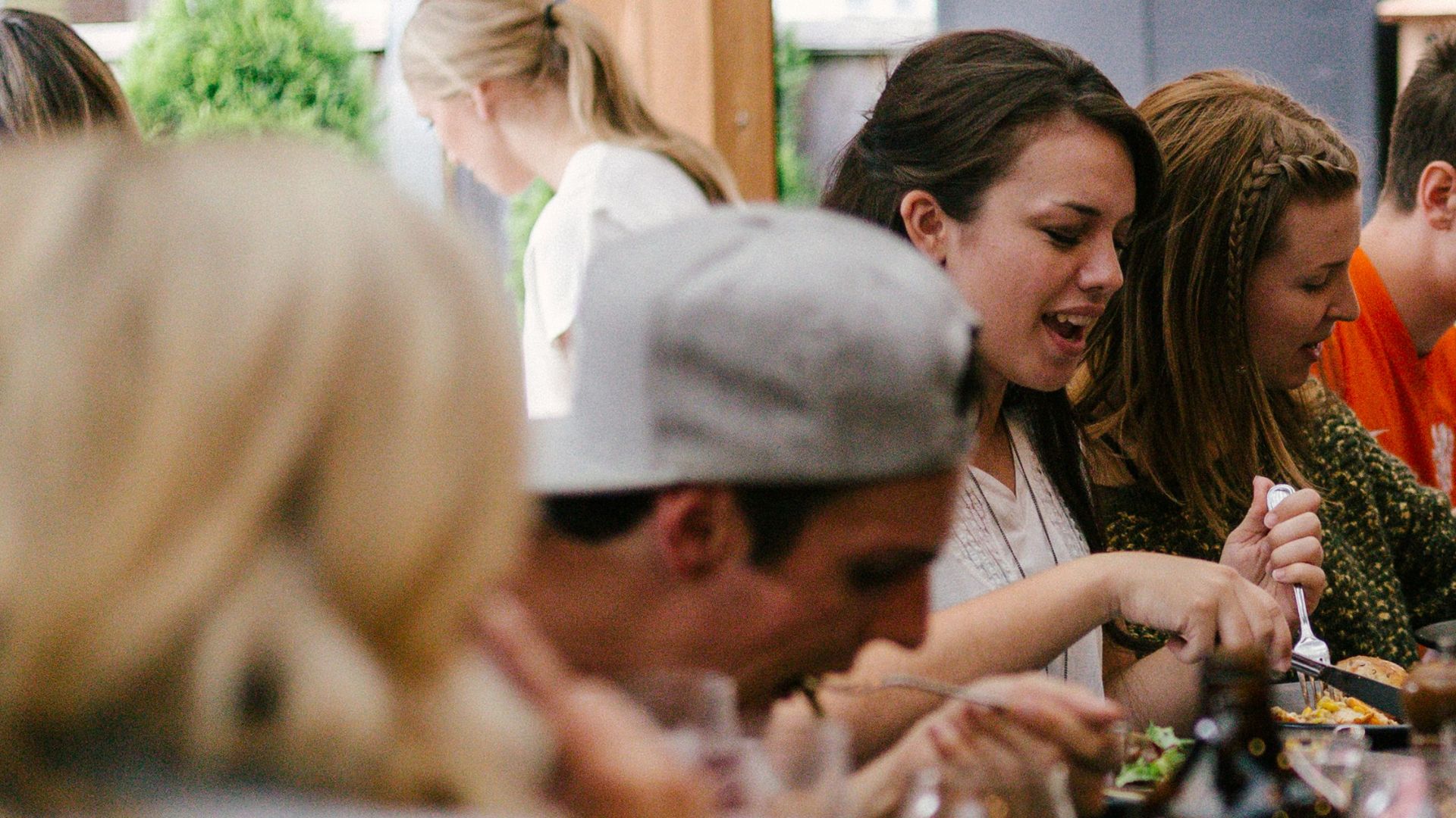 people sitting in front of table talking and eating