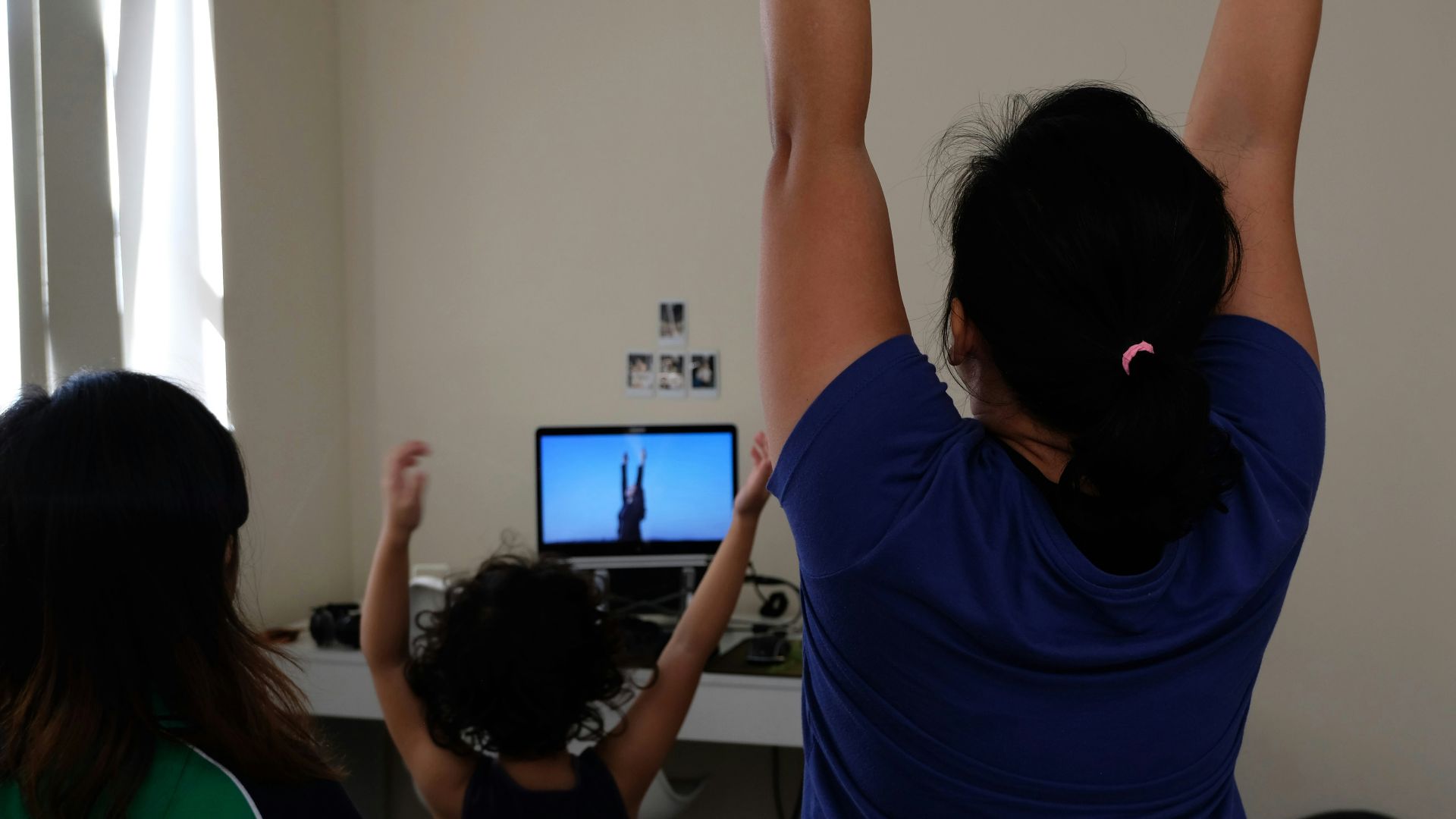 woman in blue t-shirt raising her hands
