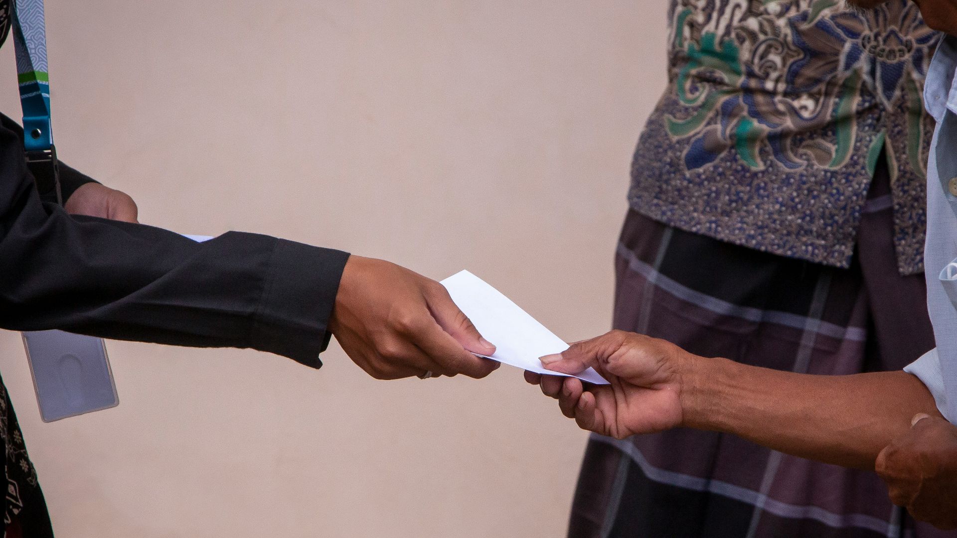 a person handing another person a piece of paper