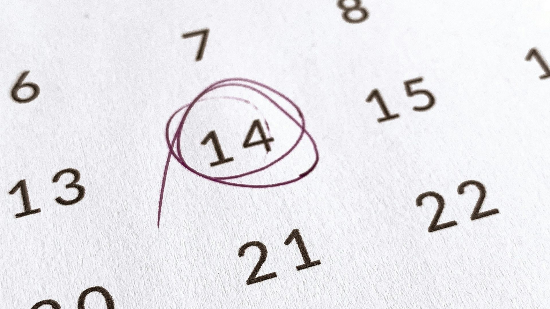 a close up of a calendar with a red marker