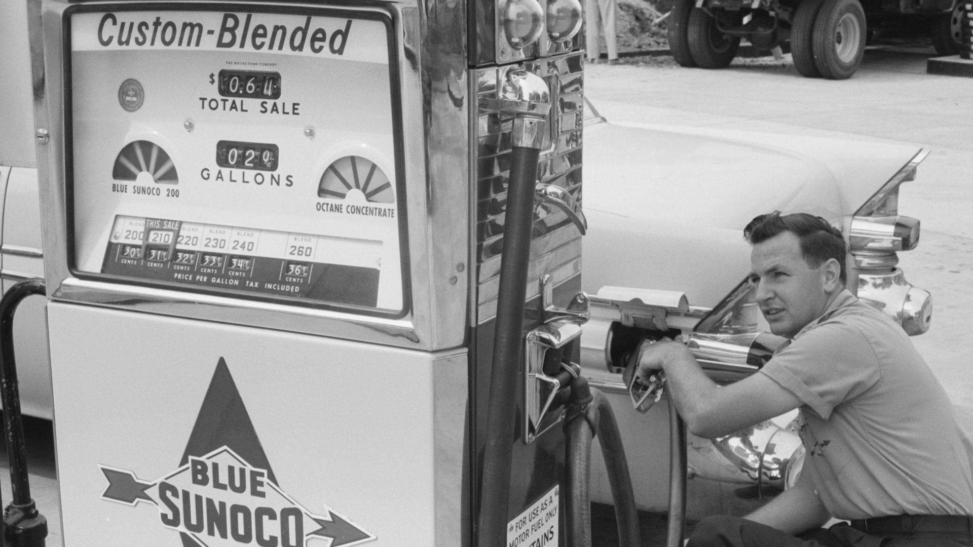 Gas station attendant filling a car tank with custom blend gas, at a Sunoco gas station, Washington, D.C. area