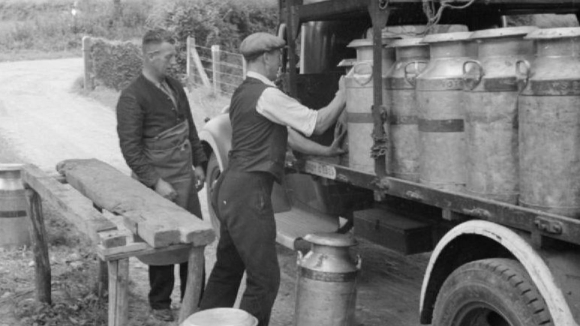 Agriculture in Britain- Life on Mount Barton Farm, Devon, England, 1942
A farmer helps load milk churns onto the lorry that will take them to the local town for delivery.  The lorry driver can be seen on the left.