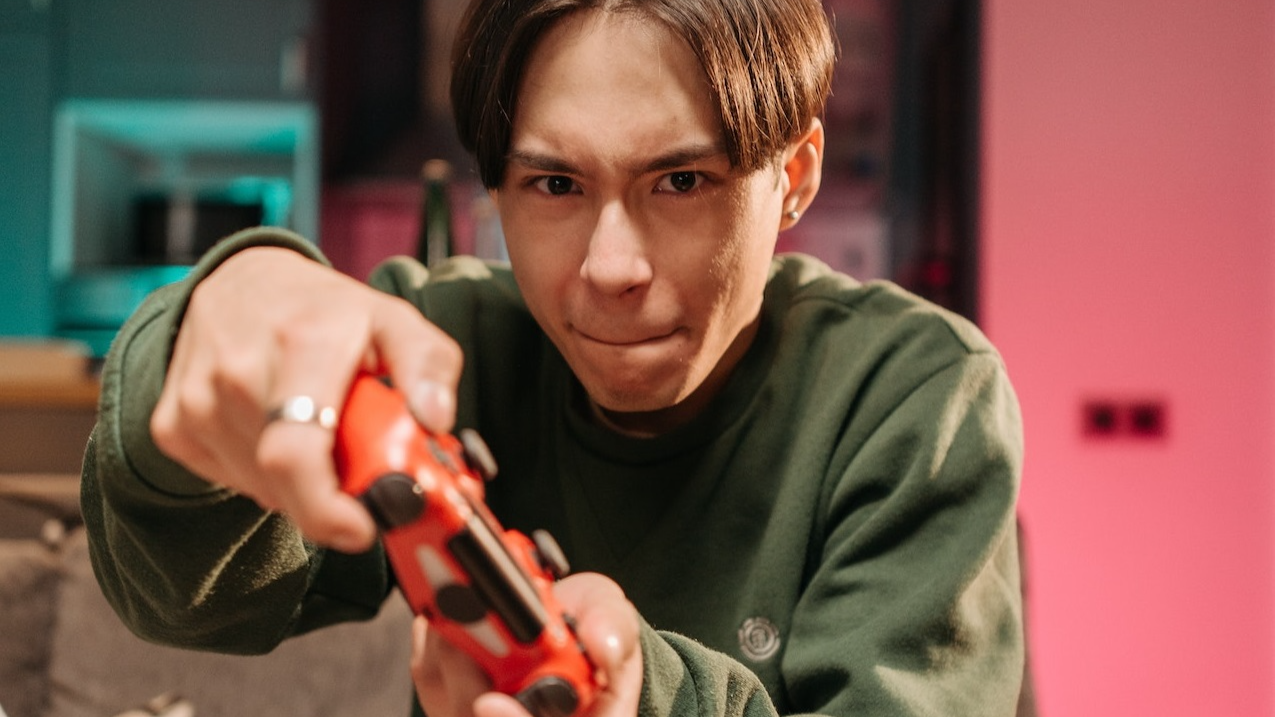 Upset young man is holding a PS controller.