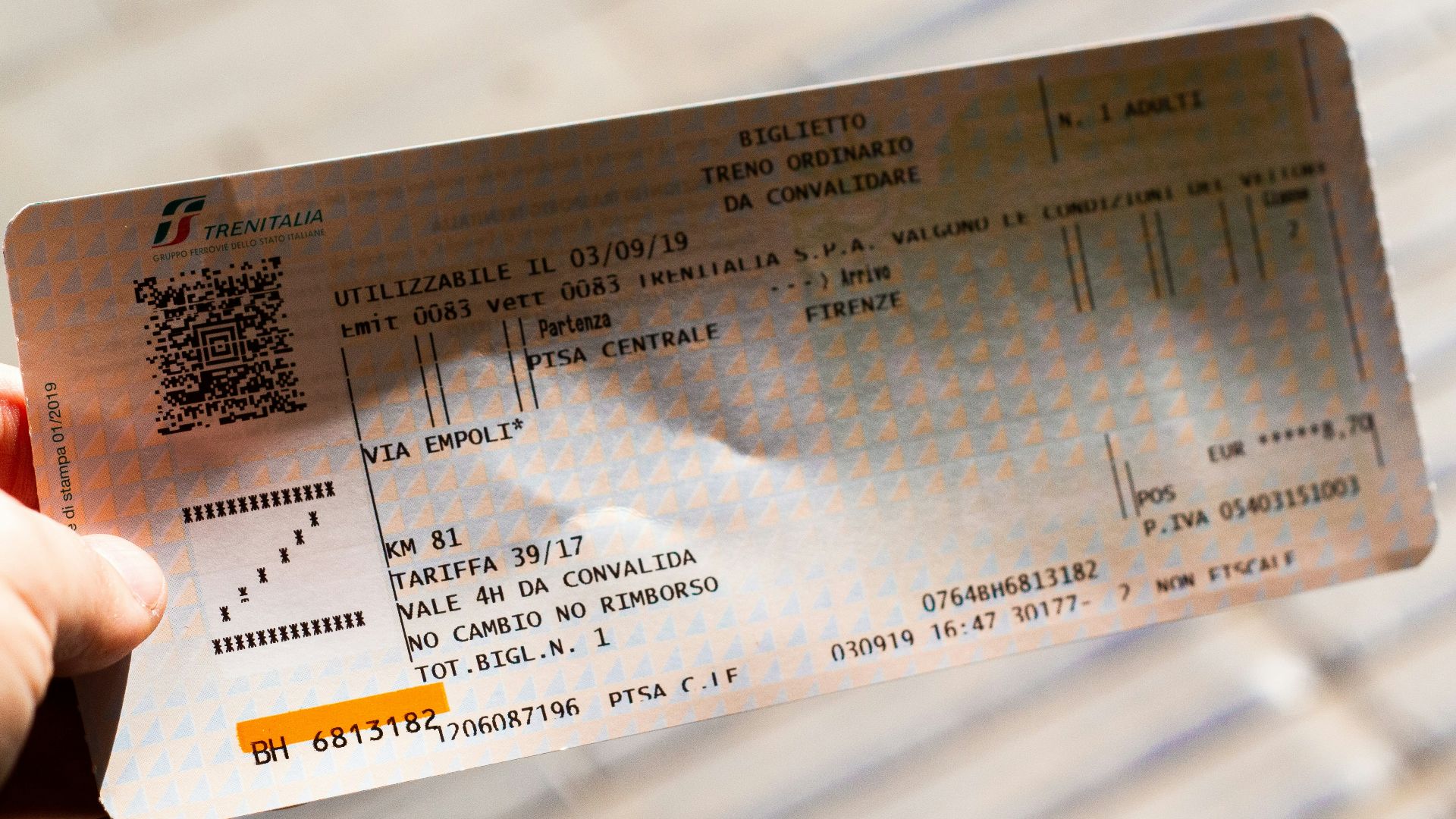 A person holding up a ticket for a concert