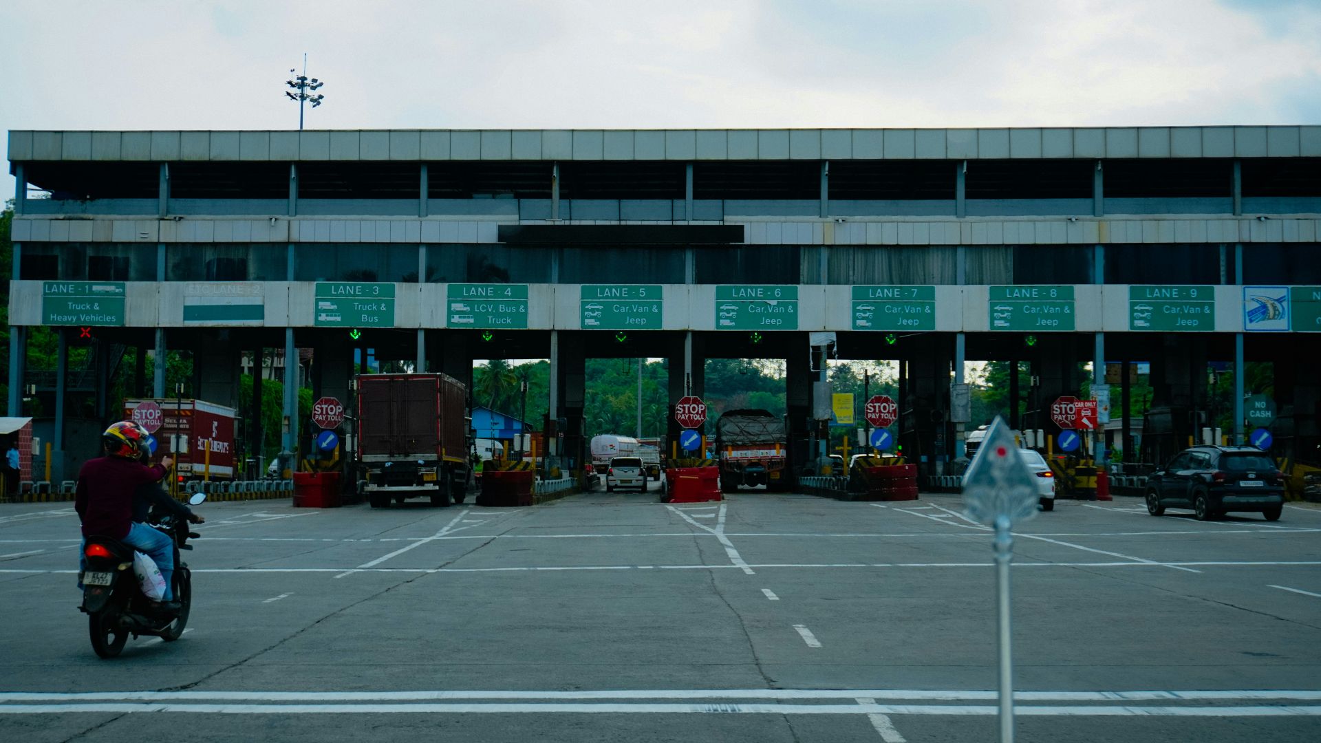 Busy toll plaza with vehicles and a motorcycle