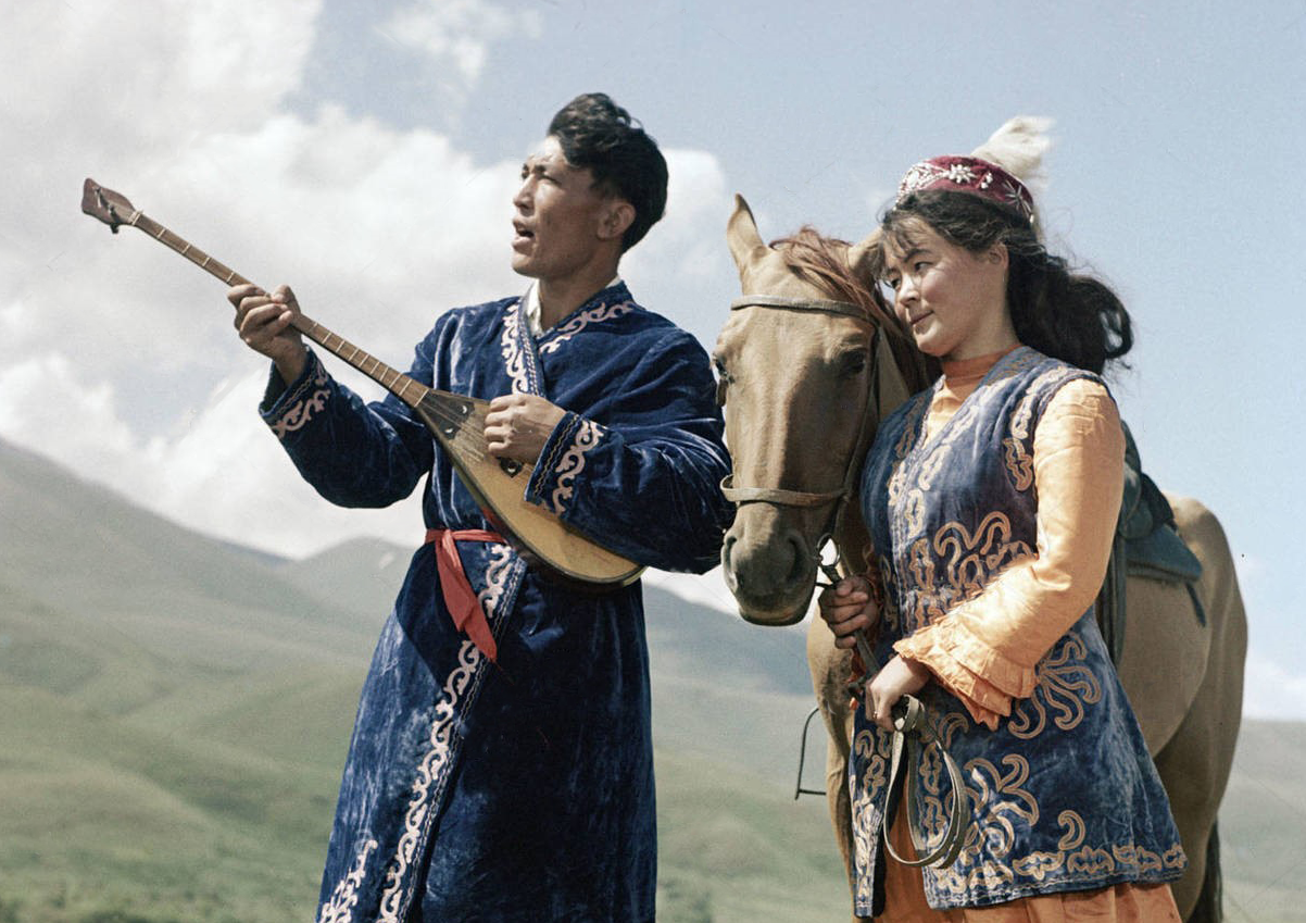 A man playing dombra and singing while a woman looks on - 1969