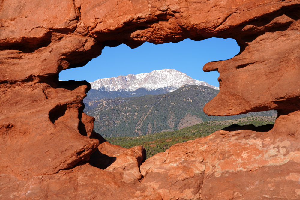 View of Pikes peak through the hole in the Siamese Twins red rock formation