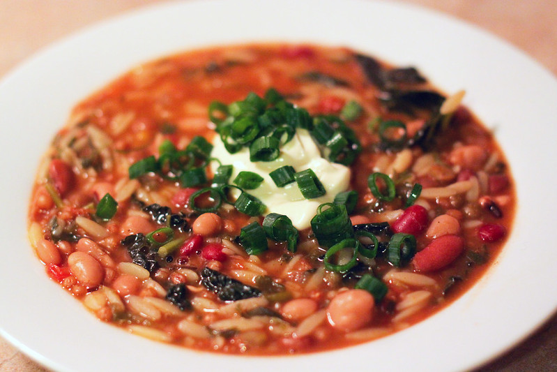 Close-up photo of a Soup Beans in a white plate placed on a table.