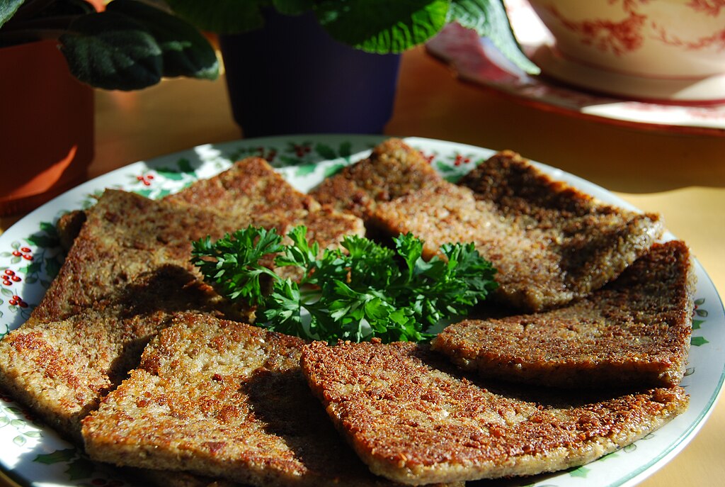 A pound of sliced, pan-fried livermush on a white plate
