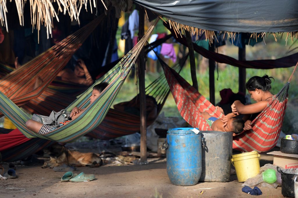 Children rest on hammocks at a Nukak campsite