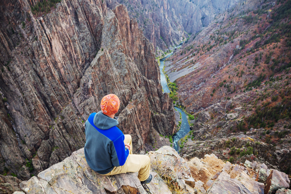 Tourist on the granite cliffs of the Black Canyon of the Gunnison, Colorado, USA