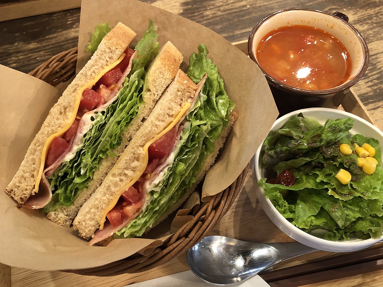 A photo of a BLT sandwich with side sauces