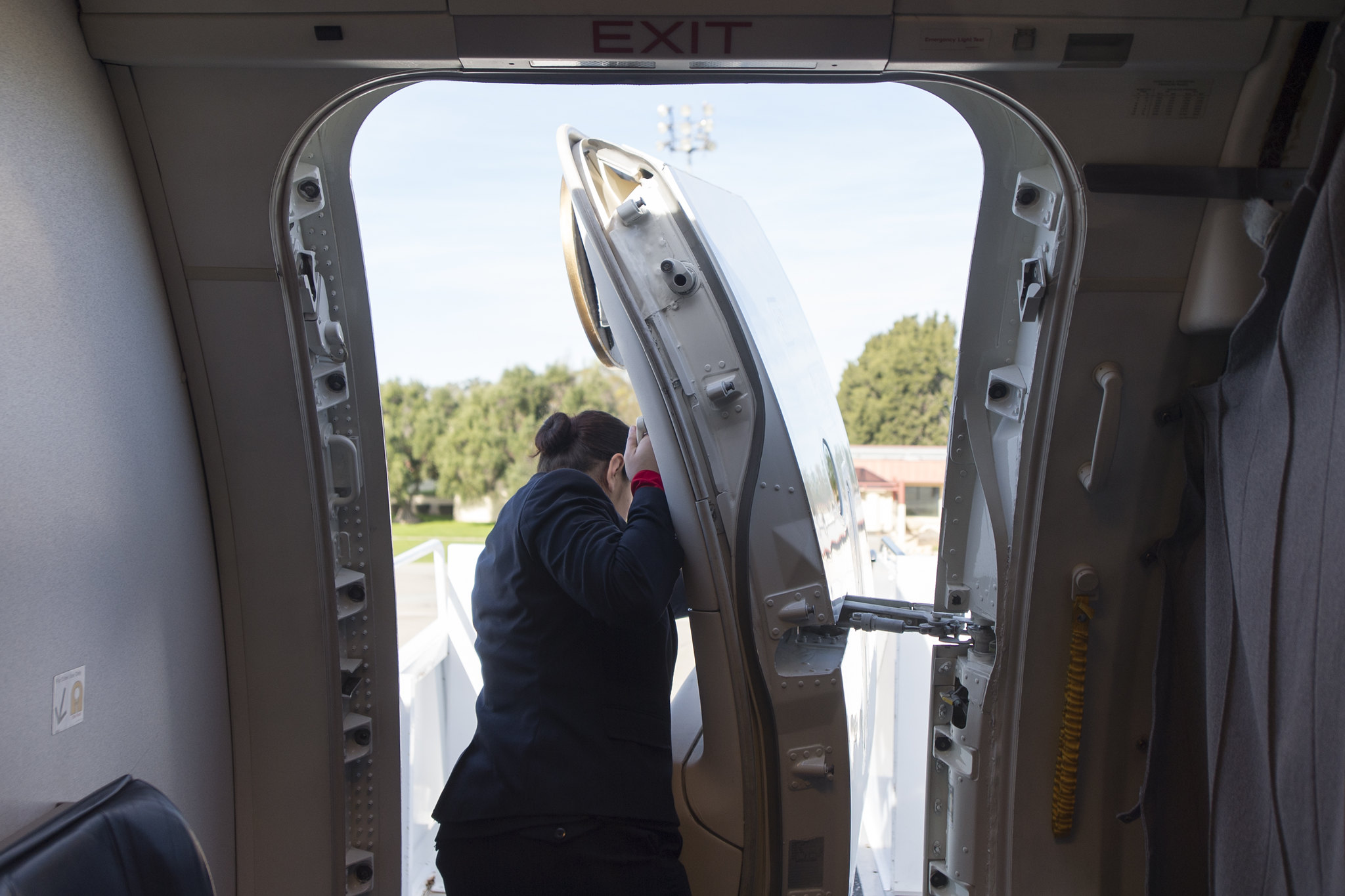 A flight attendant opening an airplane door