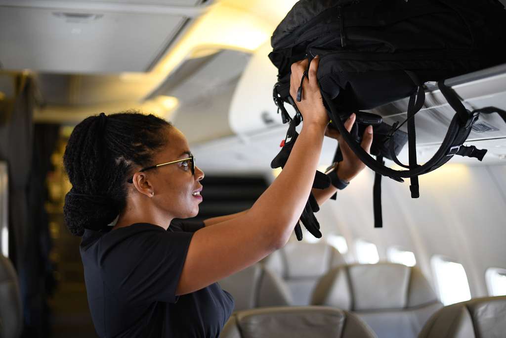 Flight Attendant Stows Luggage Prior To Departure