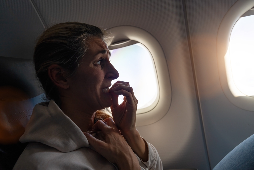 Woman with aerophobia in airplane cabin