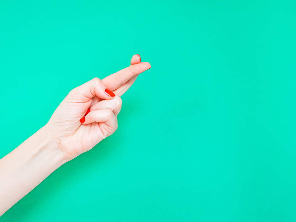 Hand with crossed fingers