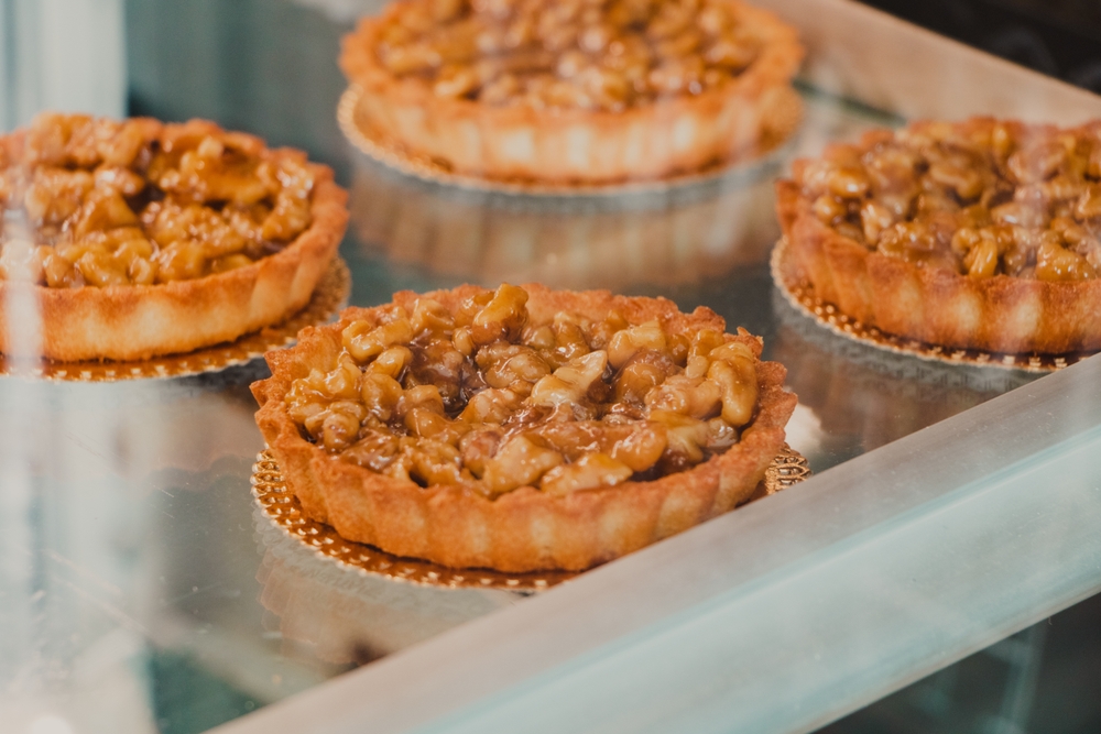 four apple pies on trays