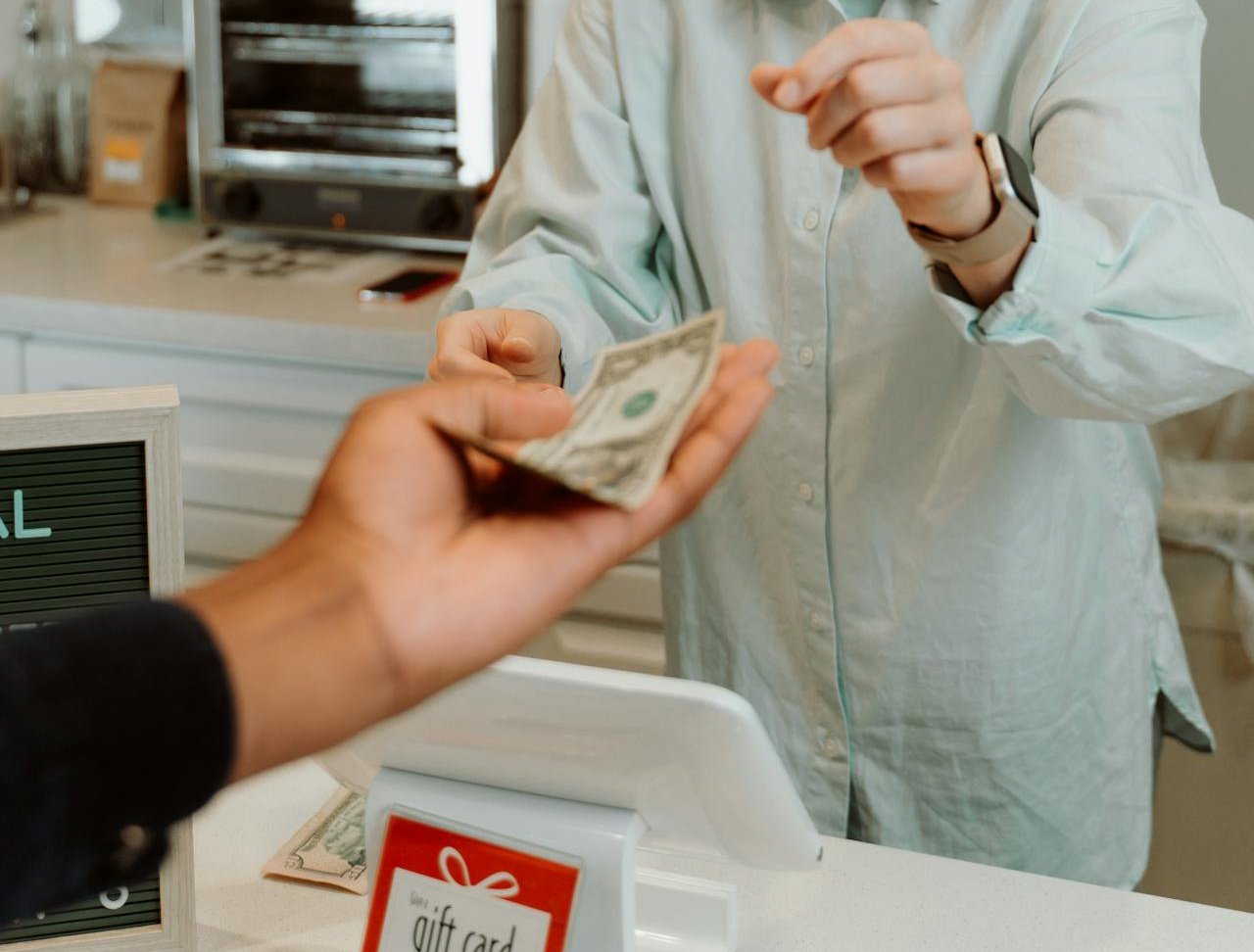 A woman in a blue shirt receiving money