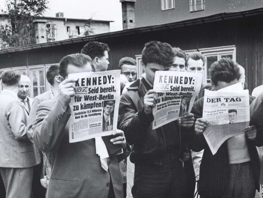 Refugees from East Germany read news accounts