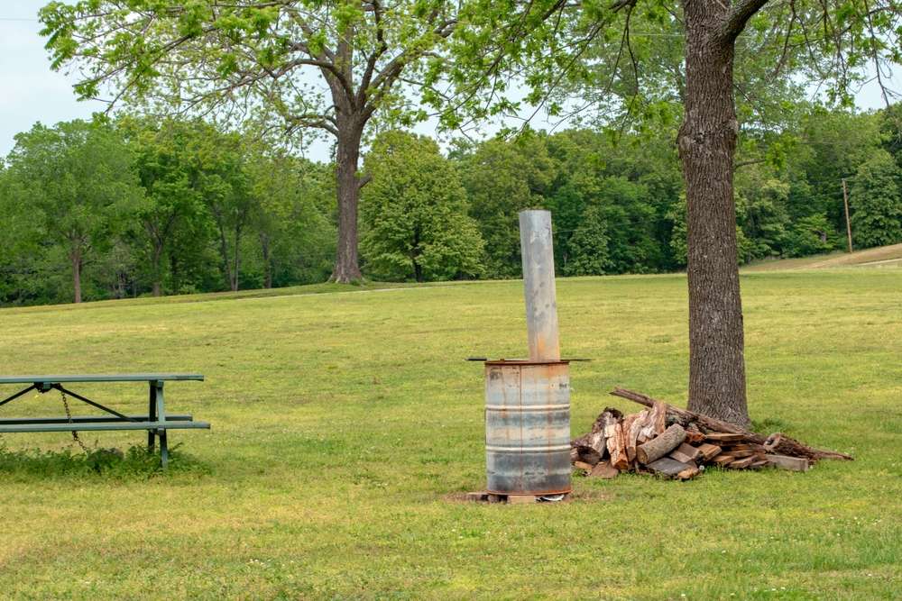 A picnic table, a homemade barrel stove and firewood makes for a perfect outdoor meal and relaxation in Oklahoma.