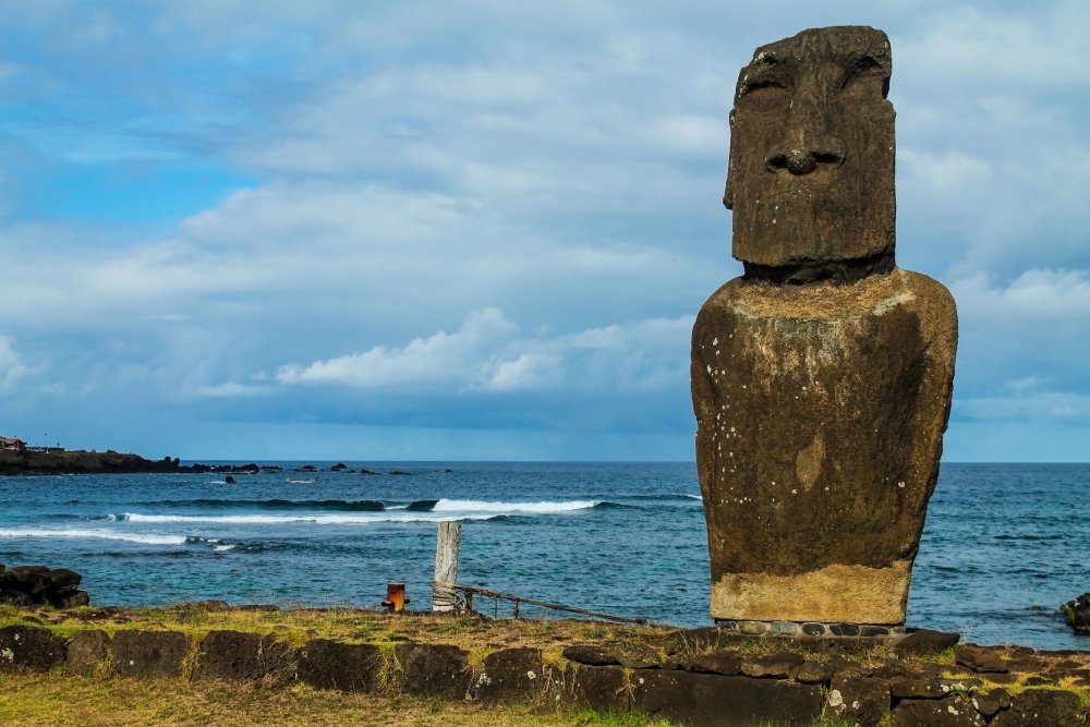 This image showcases a single moai statue standing tall on the shore of Easter Island.