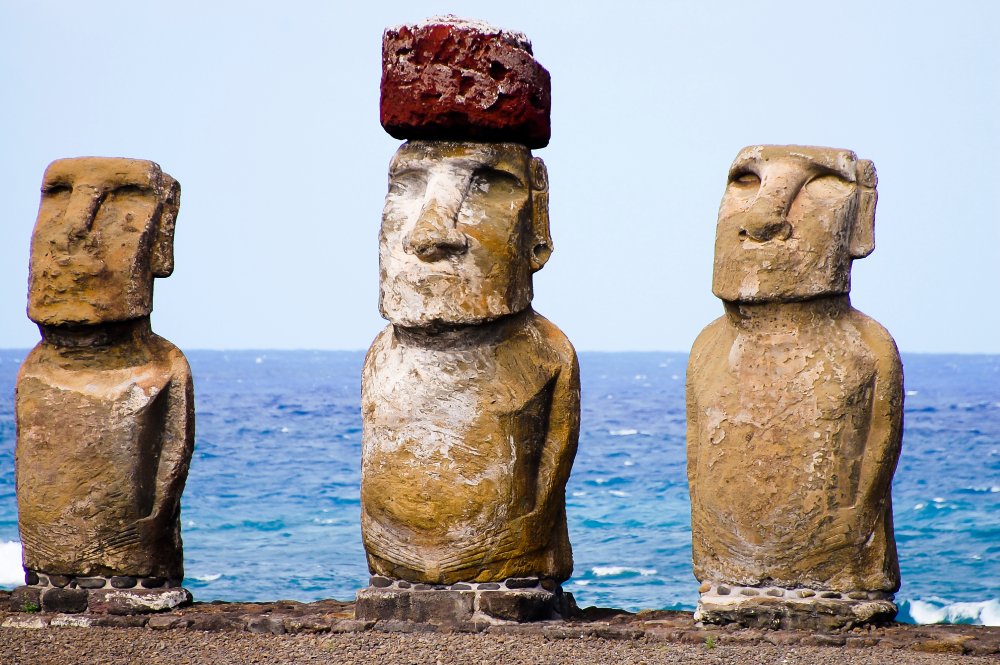 Three moai statues stand tall on Easter Island, overlooking the vast ocean