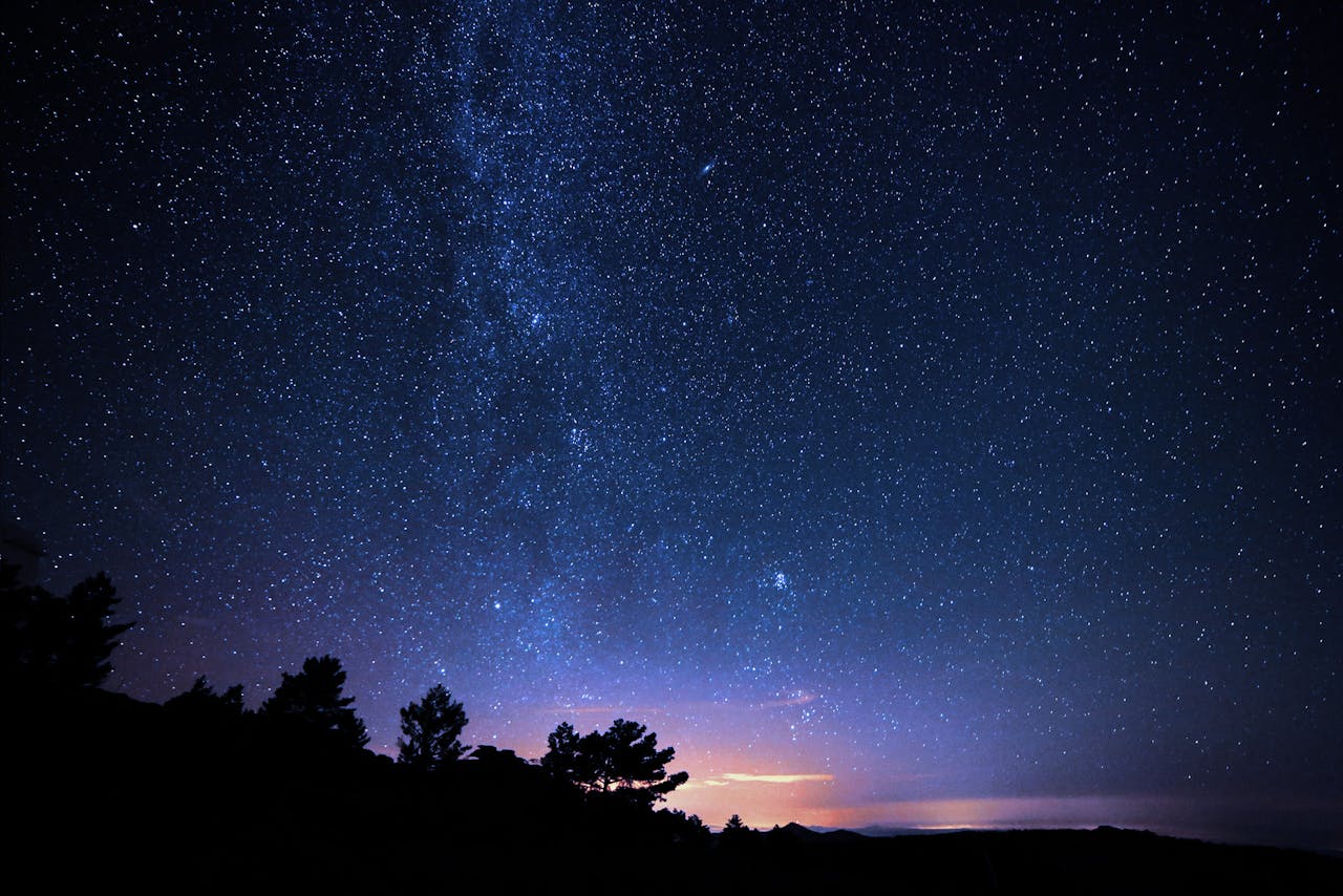 Night Photo of Starry expanse above a tranquil field.